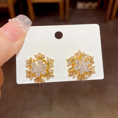 Angled view of the 14K Gold Plated Christmas Zircon Rotation Snowflake Stud Earrings