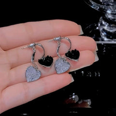 Model showcasing the dangle and style of the 14K Gold Plated Crystal Double-Heart Earrings