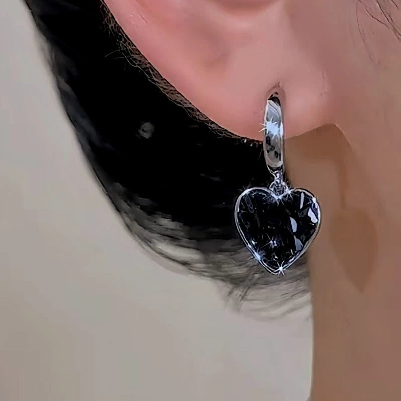 Close-up detail of the sparkling zircons and plating on the gold heart earrings