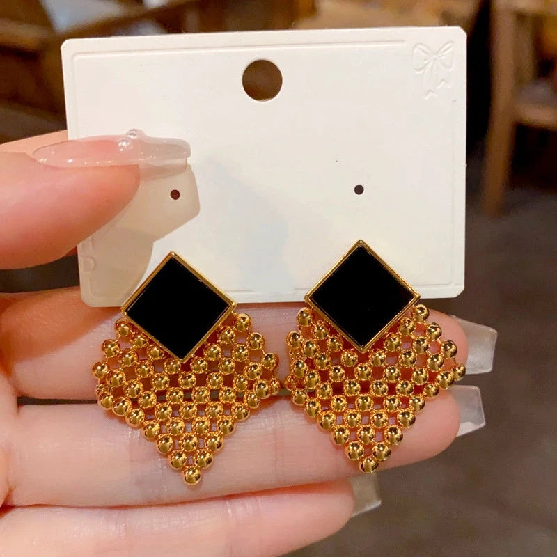 Close-up detail of the sparkling zircons and plating on the gold tassel earrings