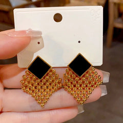 Close-up detail of the sparkling zircons and plating on the gold tassel earrings