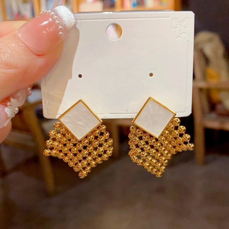 Angled view of the 14K Gold Plated Crystal Tassel Earrings