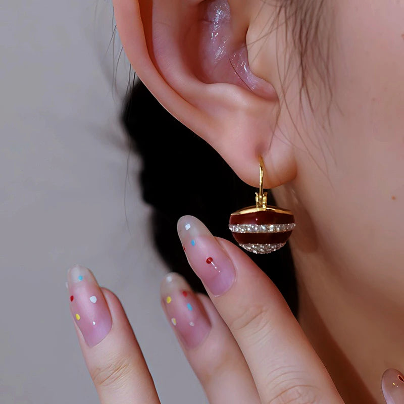 Close-up detail of the sparkling zircons and plating on the gold drop earrings