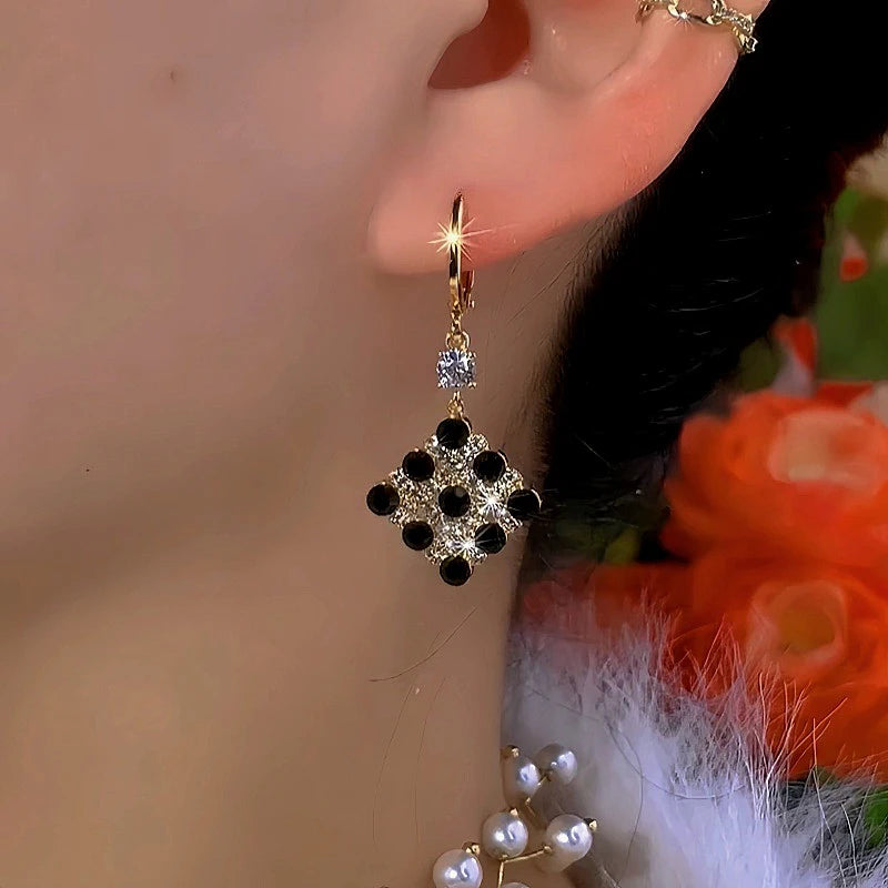 Close-up detail of the sparkling zircons and plating on the gold drop earrings