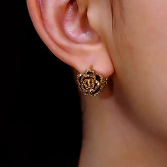 Close-up detail of the sparkling zircons and plating on the gold flower earrings