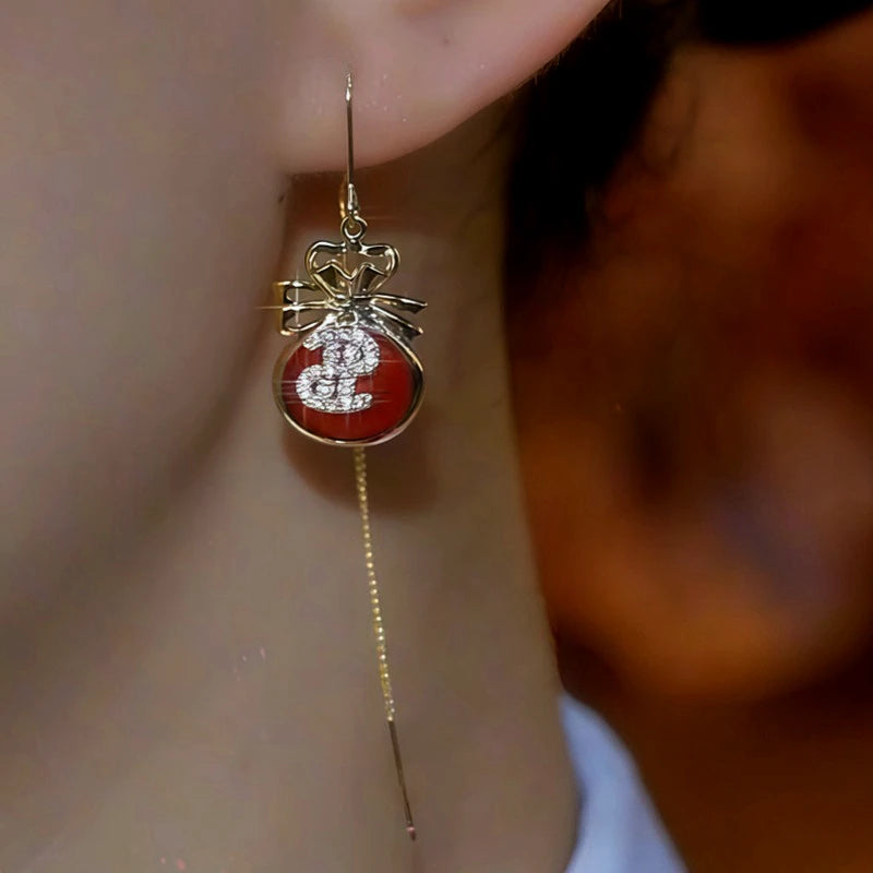 Model showcasing the dangle and style of the 14K Gold Plated Diamond Lucky Bag Threader Earrings