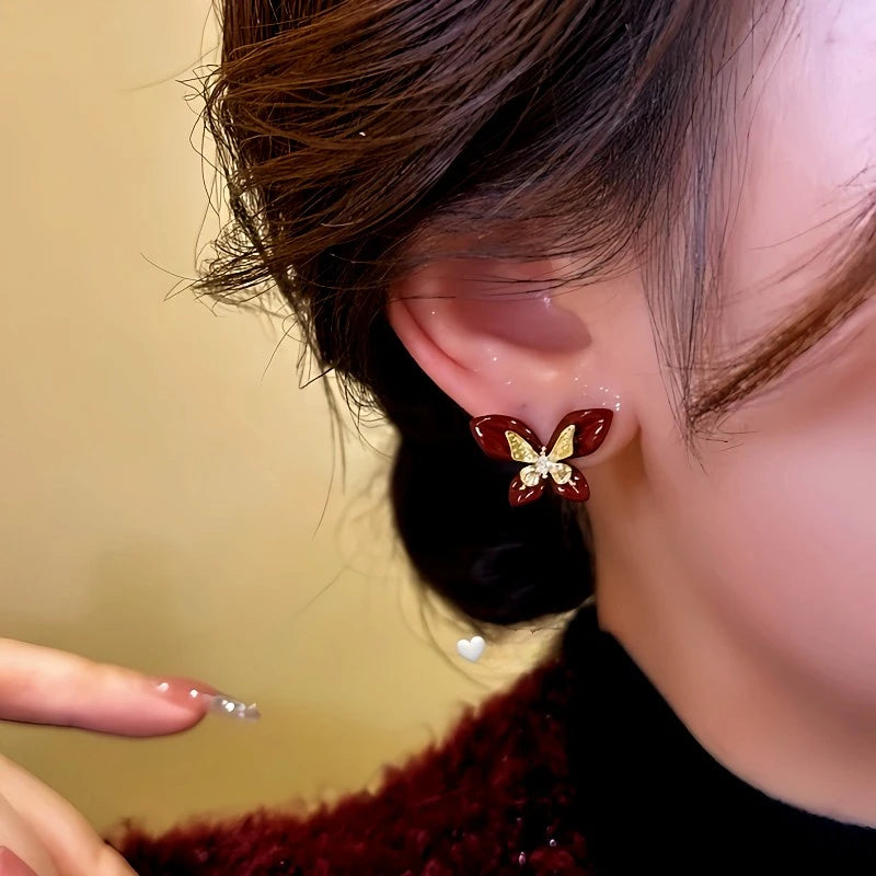 Close-up detail of the sparkling zircons and plating on the gold butterfly earrings