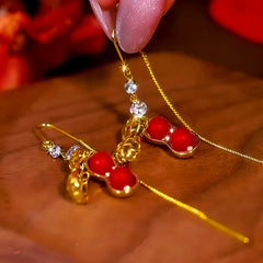 Angled view of the 14K Gold Plated Diamond Red Pearl Peanut Threader Earrings