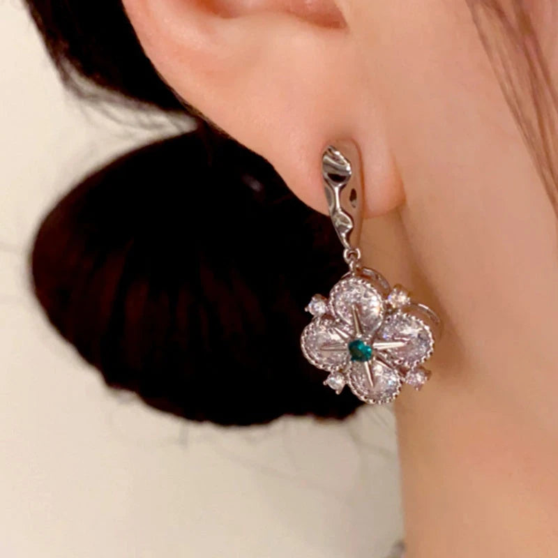 Model showcasing the dangle and style of the 14K Gold Plated Diamond Star Four-Leaf Flower Earrings