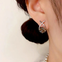 Close-up detail of the sparkling zircons and plating on the gold stud earrings