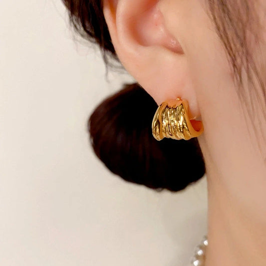 Model showcasing the dangle and style of the 14K Gold Plated Folded Leaf Earrings