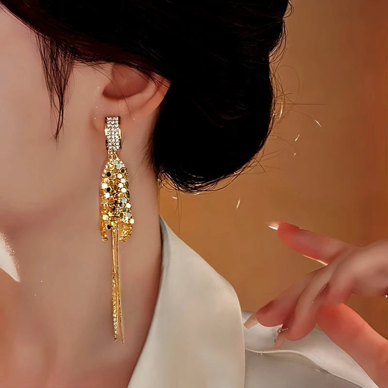 Close-up detail of the sparkling zircons and plating on the gold tassel earrings