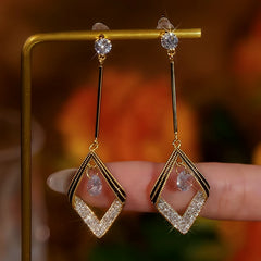 Close-up detail of the sparkling zircons and plating on the gold geometric earrings
