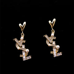 Model showcasing the dangle and style of the 14K Gold Plated Heart Zircon Letter Pearl Earrings