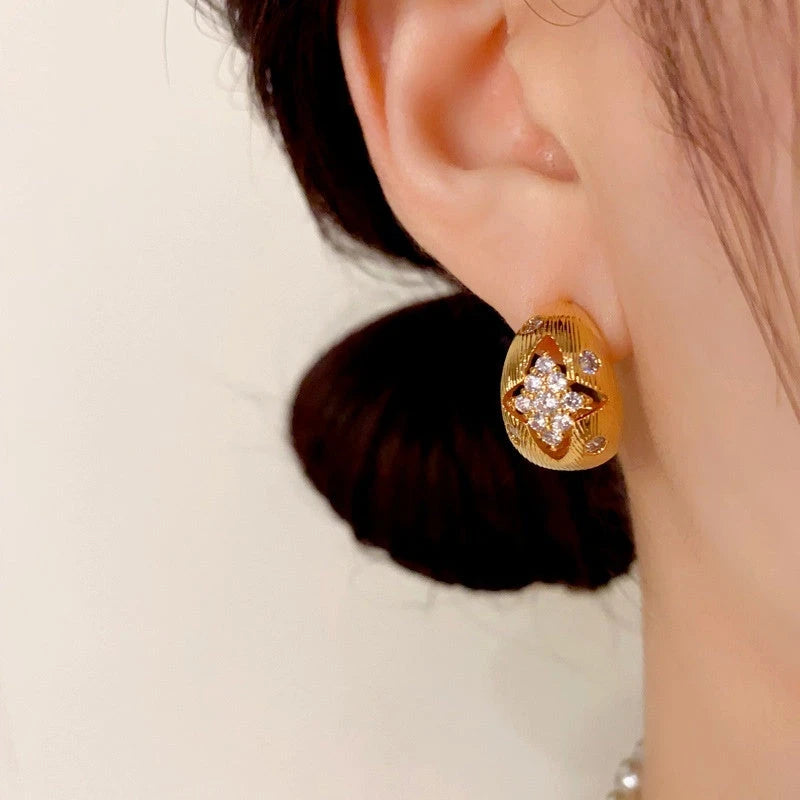 Close-up detail of the sparkling zircons and plating on the gold drop earrings