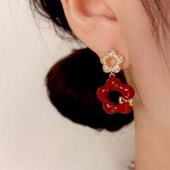 Model showcasing the dangle and style of the 14K Gold Plated Hollow Petal Flower Earrings