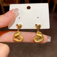 Close-up detail of the sparkling zircons and plating on the gold heart earrings