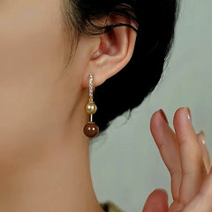 Model showcasing the dangle and style of the 14K Gold Plated Pearl Earrings