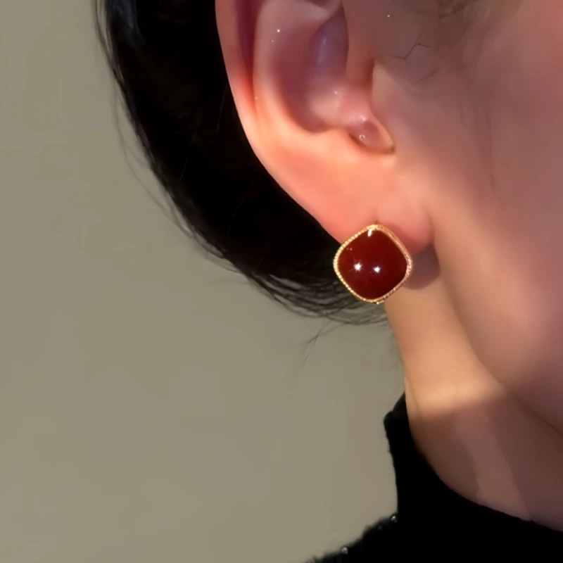 Model showcasing the dangle and style of the 14K Gold Plated Red Oil Drop Zircon Cube Earrings