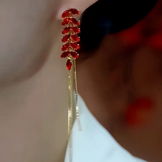 Model showcasing the dangle and style of the 14K Gold Plated Red Wheat Diamond Tassel Earrings
