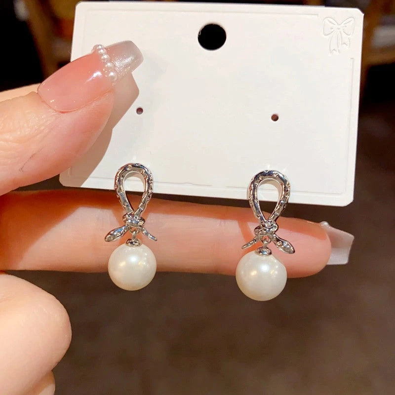 Angled view of the 14K Gold Plated Snake Knotted Pearl Earrings