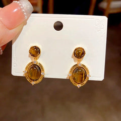 Angled view of the 14K Gold Plated Tiger Eye Stone Oval Earrings