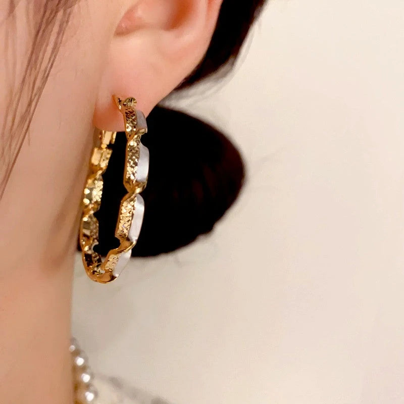 Model showcasing the dangle and style of the 14K Gold Plated Twisted Hoop Earrings