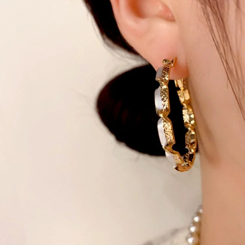 Close-up detail of the sparkling zircons and plating on the gold hoop earrings