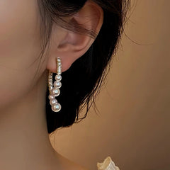 Model showcasing the dangle and style of the 14K Gold Plated Zircon Arc-Shaped Pearl Earrings