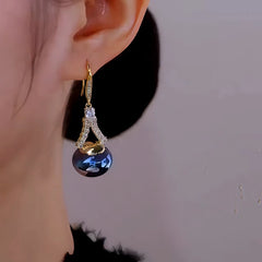 Model showcasing the dangle and style of the 14K Gold Plated Zircon Blue Pearl Ear Hook Earrings