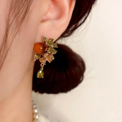 Model showcasing the dangle and style of the 14K Gold Plated Zircon Flower Bead Tassel Earrings