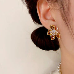 Close-up detail of the sparkling zircons and plating on the gold flower earrings
