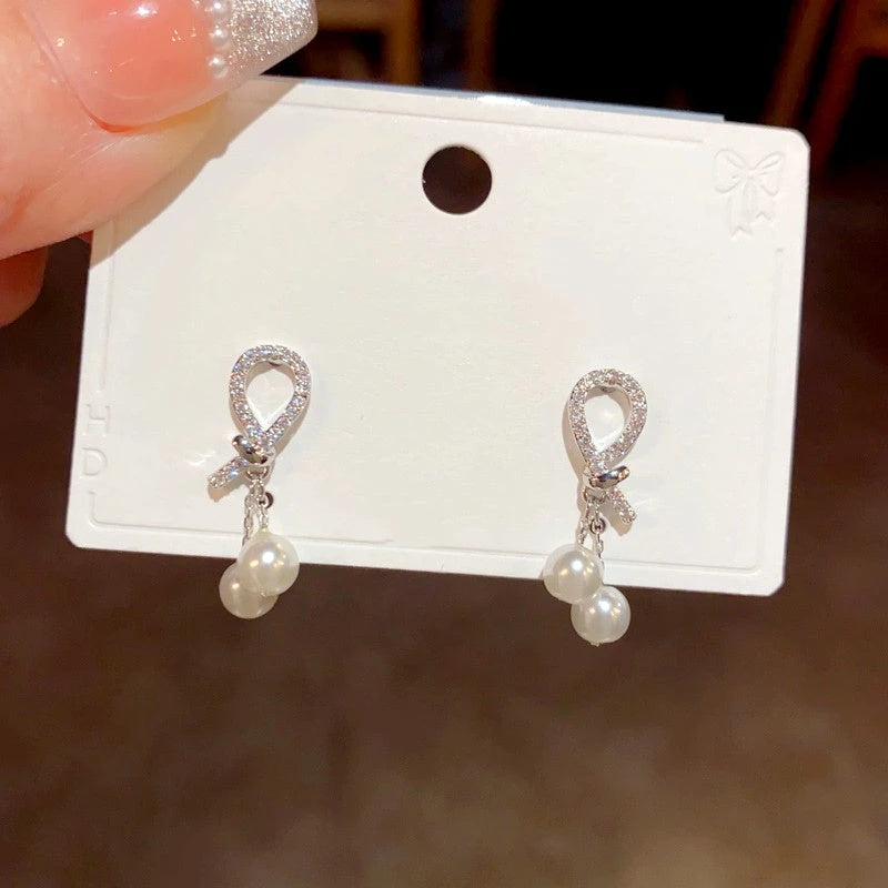 Close-up detail of the sparkling zircons and plating on the gold pearl earrings