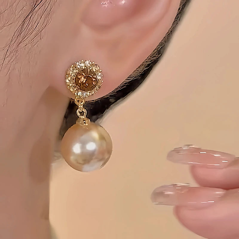 Model showcasing the dangle and style of the 18K Gold-Plated Brown Diamond Pearl Earrings