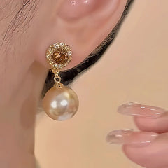 Model showcasing the dangle and style of the 18K Gold-Plated Brown Diamond Pearl Earrings