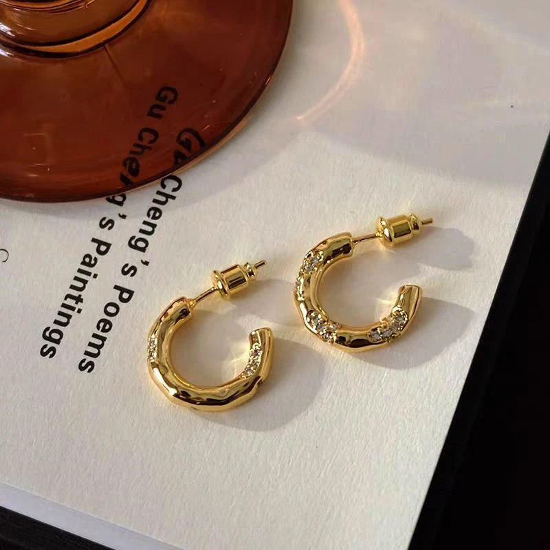 Angled view of the 18K Gold-Plated Diamond-Studded C-Shaped Earrings