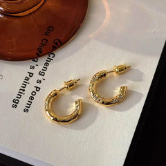 Angled view of the 18K Gold-Plated Diamond-Studded C-Shaped Earrings