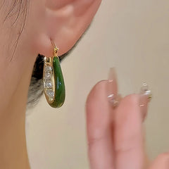 Model showcasing the dangle and style of the 18K Gold-Plated Diamond Green Oil Drop Earrings