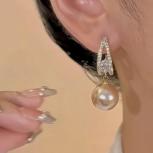 Model showcasing the dangle and style of the 18K Gold-Plated Diamond Pearl Drop Earrings