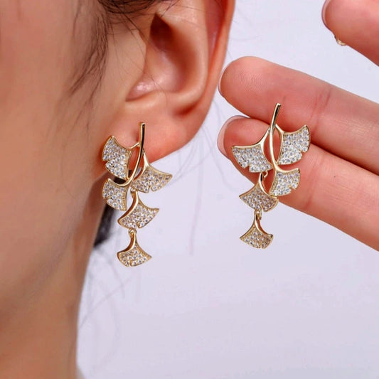 Model showcasing the dangle and style of the 18K Gold-Plated Ginkgo Leaf Earrings