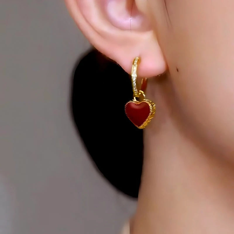Model showcasing the dangle and style of the 18K Gold-Plated Heart Earrings