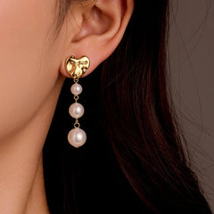 Model showcasing the dangle and style of the 18K Gold-Plated Heart Pearl Earrings