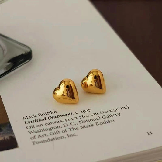 Model showcasing the dangle and style of the 18K Gold-Plated Heart Stud Earrings