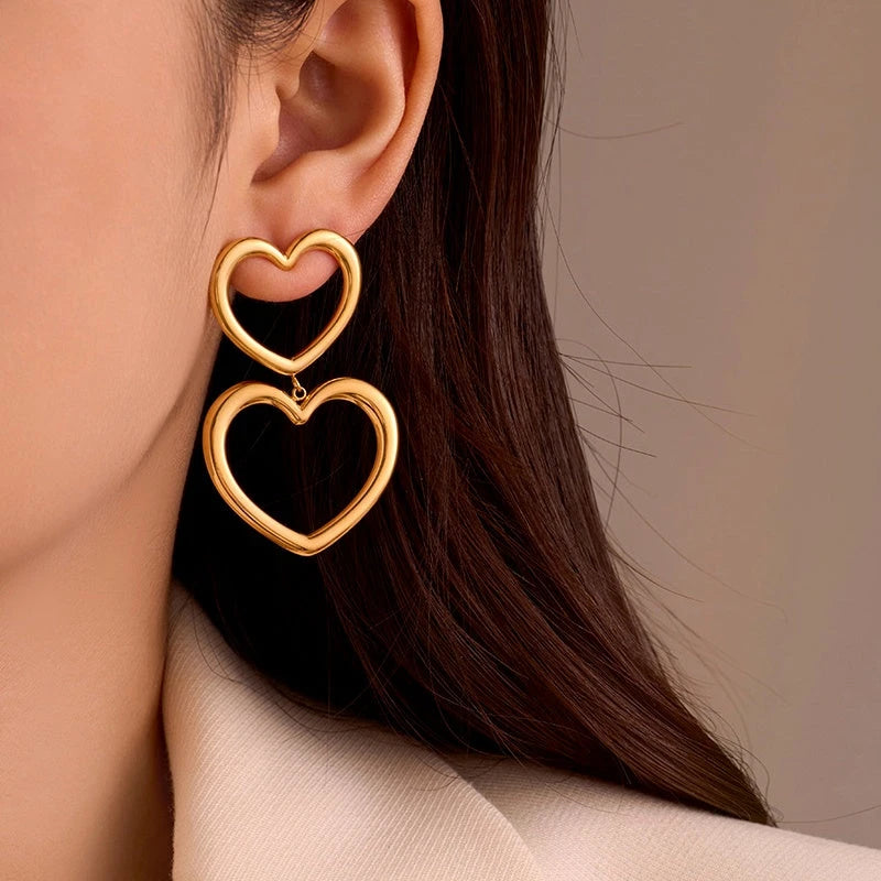 Model showcasing the dangle and style of the 18K Gold-Plated Hollow Double-Heart Earrings