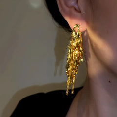 Model showcasing the dangle and style of the 18K Gold-Plated Leaf Tassel Earrings