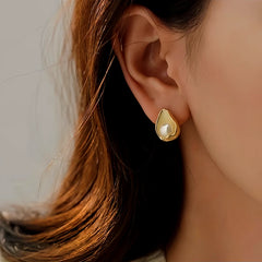 Gold teardrop pearl stud earring worn on female ear, elegant fashion jewelry