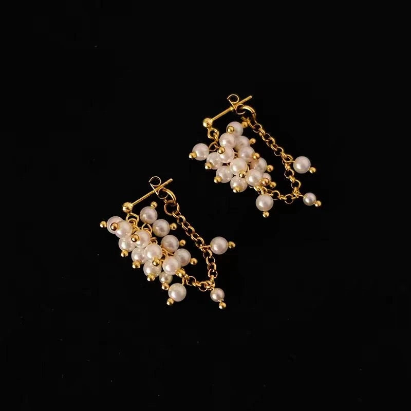 Gold freshwater pearl cluster dangle earrings product shot on black background