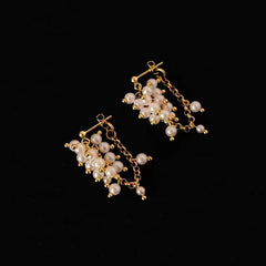 Gold freshwater pearl cluster dangle earrings product shot on black background