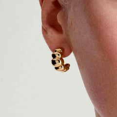 Gold beaded C-shaped hoop earring on ear, alternate angle close-up