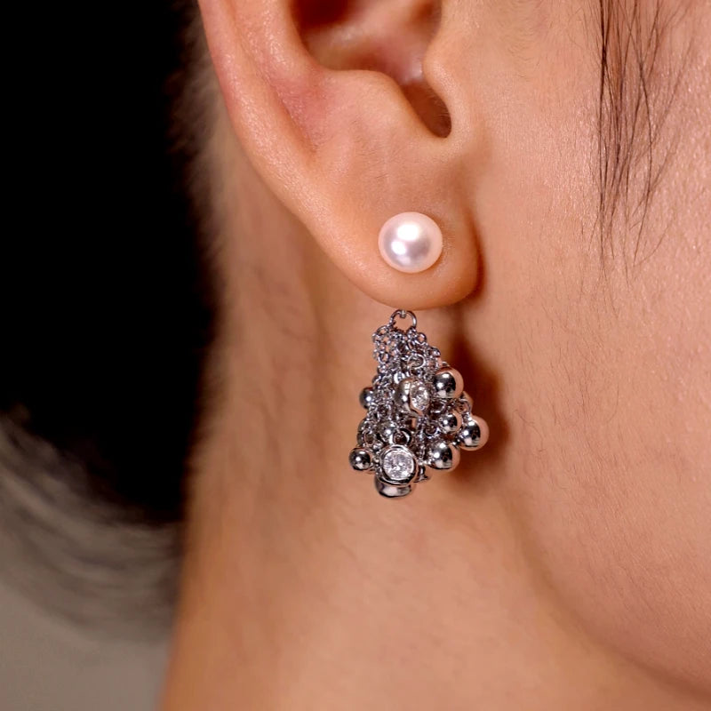 Pearl stud earring with silver beaded cubic zirconia drop, worn on earlobe